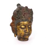 A cast iron head of Guanyin, with flower headdress and ornate chignon,