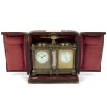 An Edwardian clock/barometer, in a gilt brass case, with central thermometer and compass to the top,