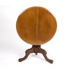 A circular mahogany table, on a turned column and carved tripod support,