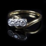 A three-stone diamond ring, in a crossover setting to an 18ct yellow gold shank, size N,