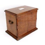 A Victorian oak stationery cabinet with hinged cover and a pair of doors,