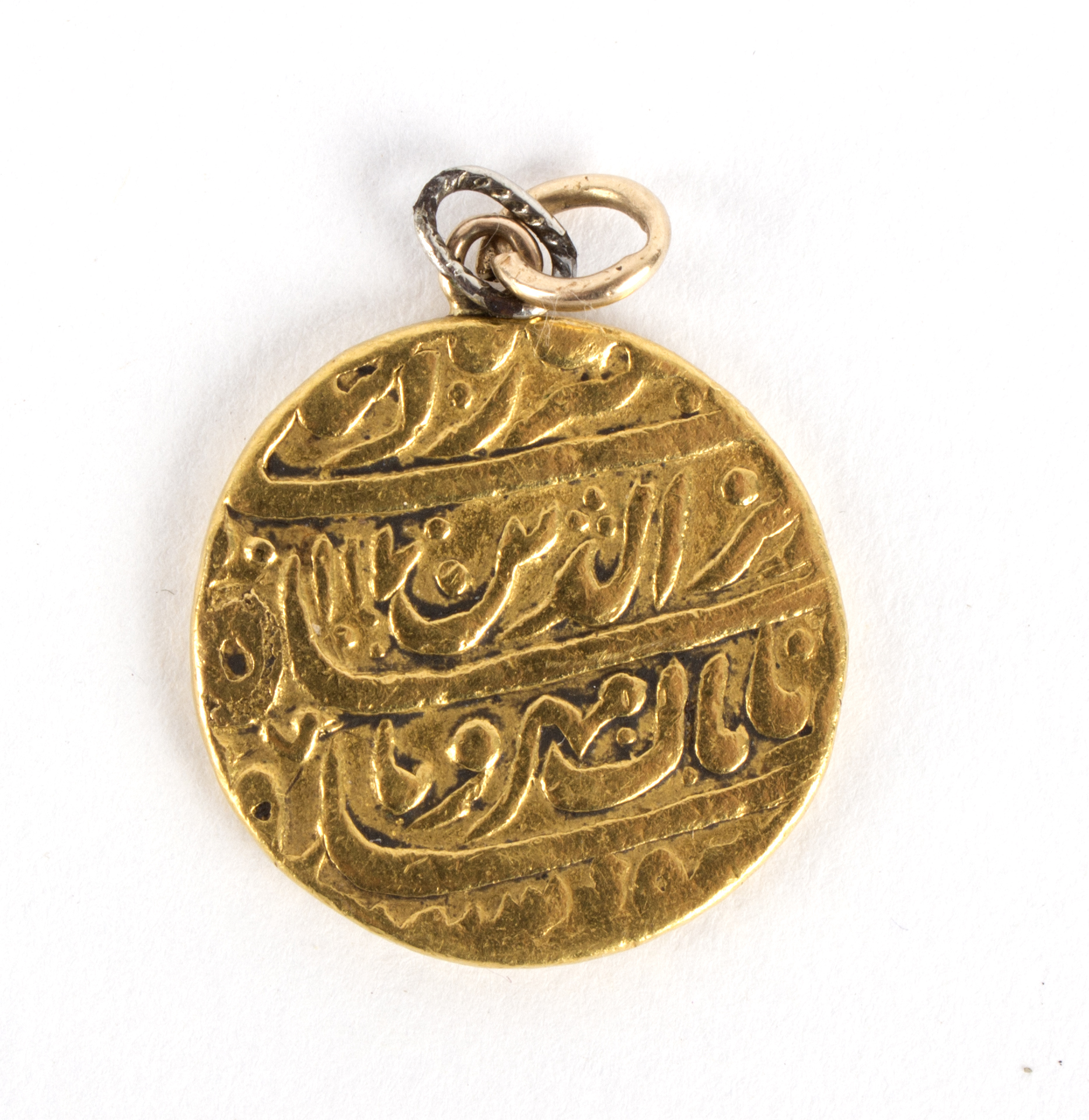 A small Islamic gold pendant, script to both sides,