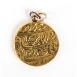 A small Islamic gold pendant, script to both sides,