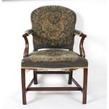 An upholstered armchair with mahogany scrolled arms and on square chamfered legs