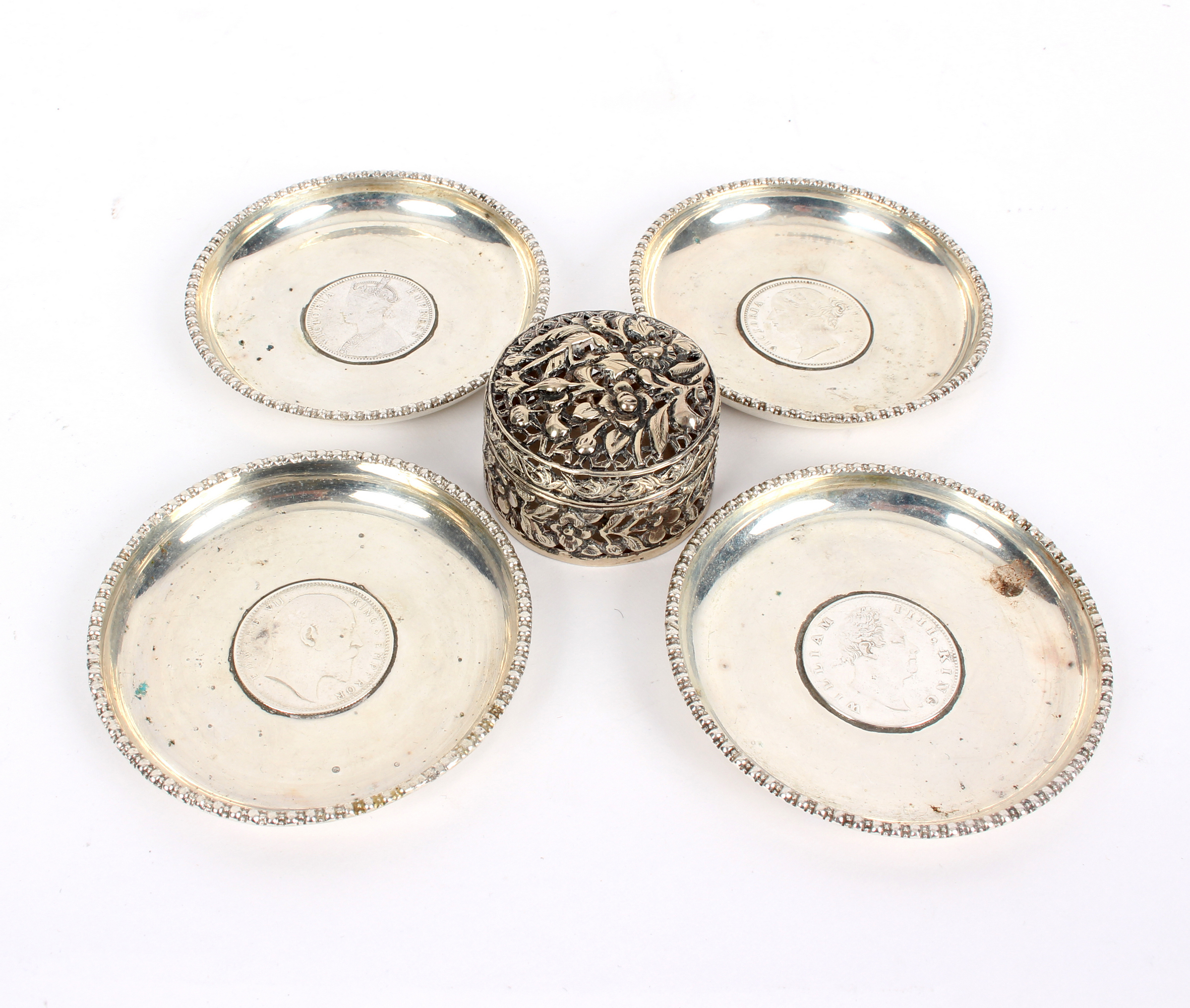 Four Indian silver ashtrays, each set with a one Rupee coin (1835, 1840,