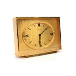A gilt metal cased mantel clock by Imhof with an oval dial and Roman numerals,