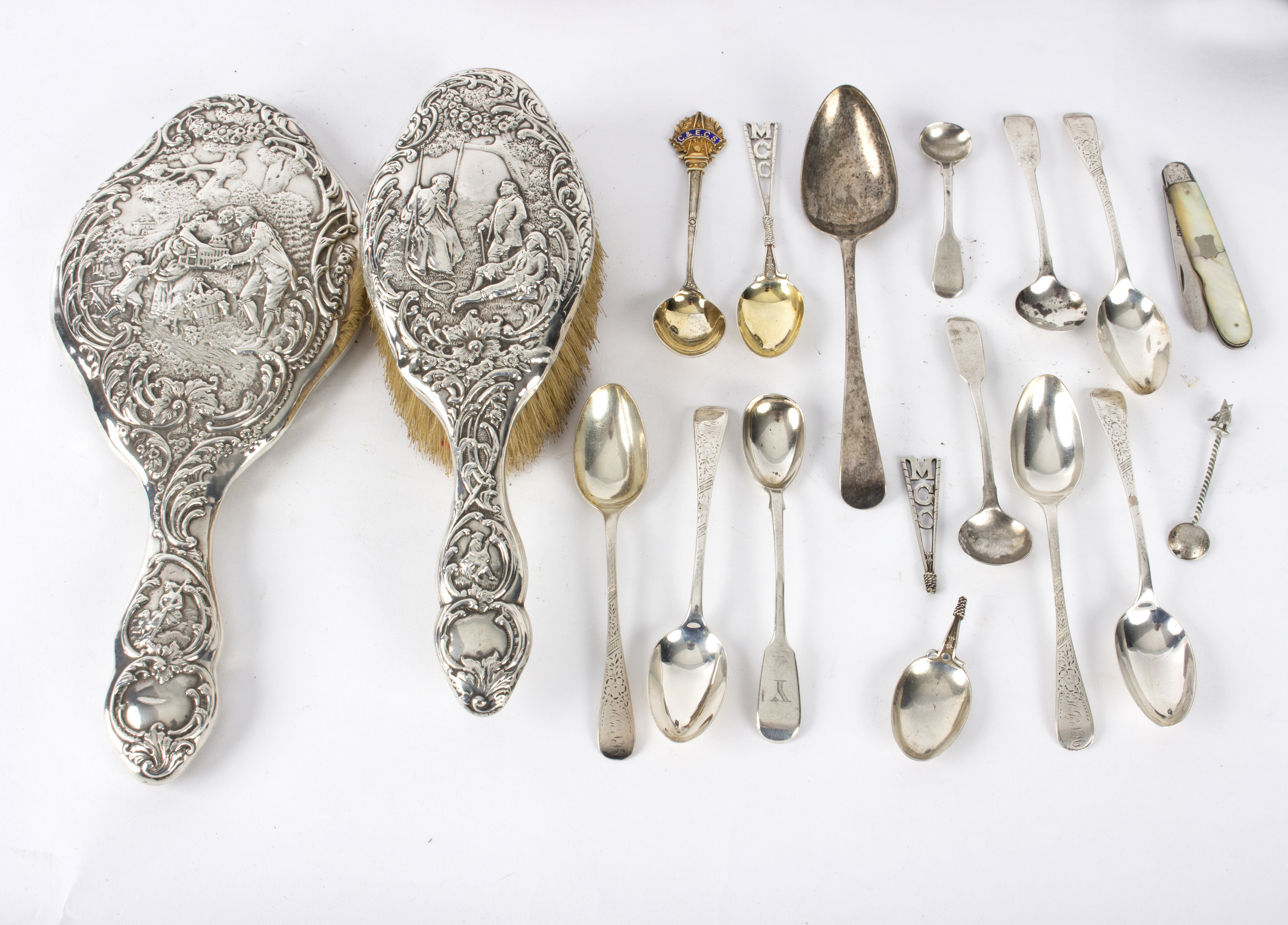 A silver backed hand mirror and brush, Chester 1901/02, decorated figures and sundry teaspoons etc.