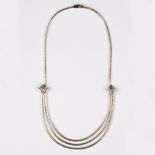 An 18ct white gold necklace, the lower section with three graduated rows of textured links,