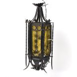 An Italian wrought iron hall lantern, of hexagonal shape with yellow tinted glass panels,