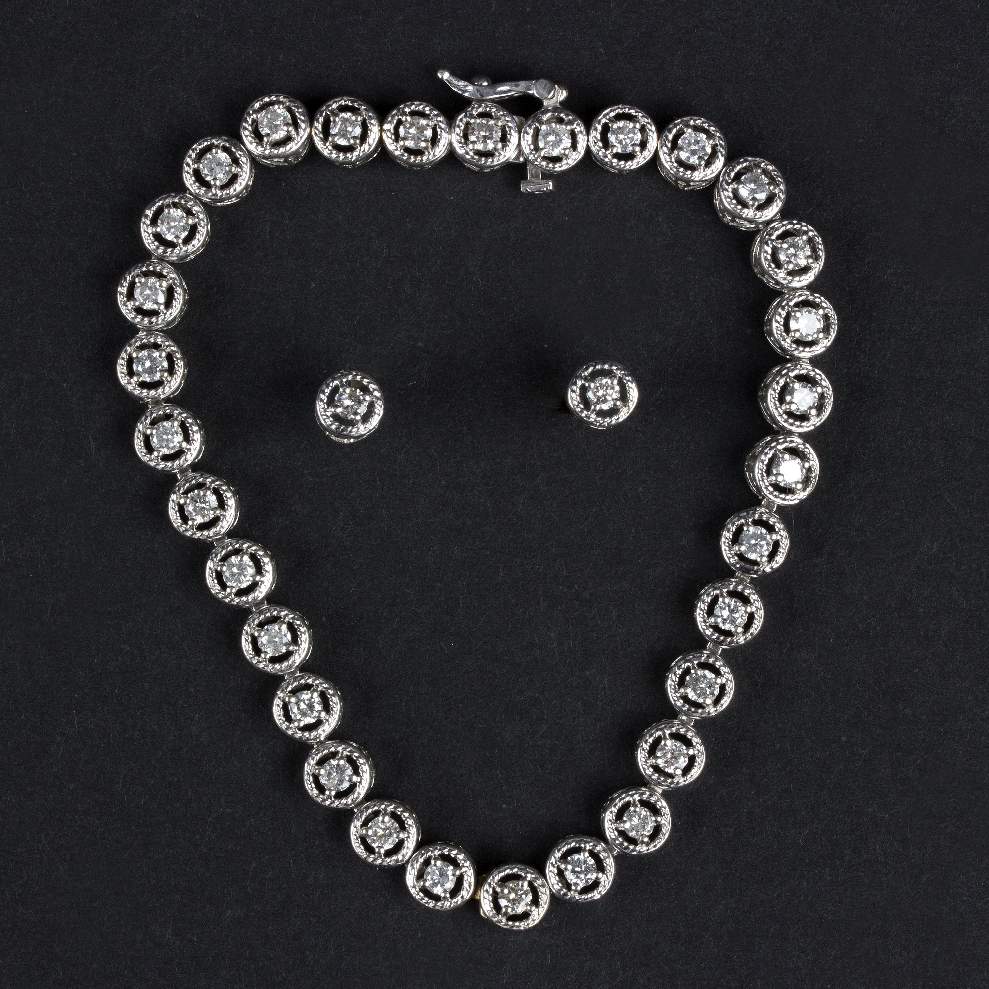 A diamond line or tennis bracelet, of thirty-one circular openwork links,