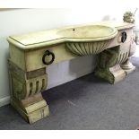 A reconstituted stone horse trough form sink, with large metal rings to the front,