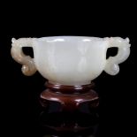 A white jade libation cup, 19th Century, of ogee form with Qilin handles,