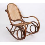 A bentwood rocking chair with cane back and seat and a mahogany torchère (converted bed posts),