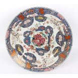 A Japanese saucer dish, painted a chrysanthemum with reserves of flowers on a blue ground, 51.