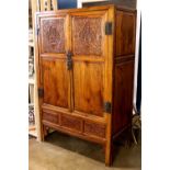 Chinese wooden cabinet, fronted by hinged double doors carved with beauties in reserves, the