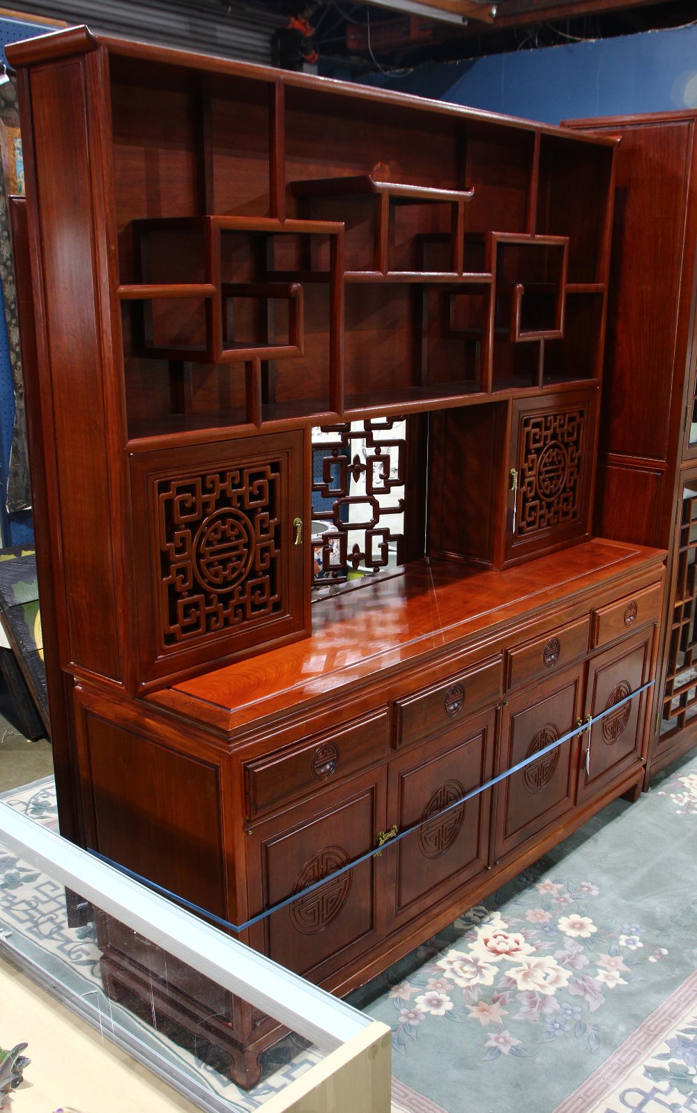 Chinese hardwood two-section cabinet, the upper piece with tiered shelves over two hinged doors