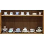 Two shelves of assorted porcelain tea cups and saucers, by various makers including Minton and