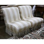 Pair of upholstered slipper chairs, each with striped ivory upholstery and tassel skirt, 33"h x 26"w