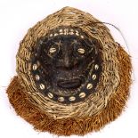 Papua New Guinea decorative mask, with cowrie shell eyes and a woven halo and raffia beard, 13"h x