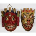 (lot of 2) Himalayan/Tibetan polychrome wooden masks, both featuring wrathful deities surmounted