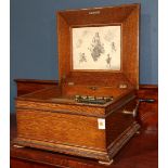 Victorian Regina music player, the oak case having a hinged top opening to reveal the comb player,