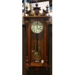 Austrian walnut regulator clock, having spherical finials, above a figural medallion, continuing