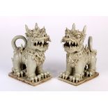 (lot of 2) Southeast Asian ceramic figures, the stylized lions in formal stance on a plinth, 6.75"h