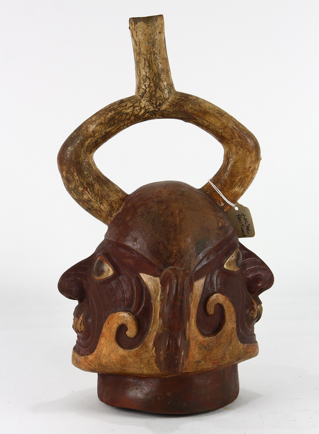 Pre-Columbian Moche stirrup vessel, depicting the head of a tribal ruler, (restored), 12"h x 6"w x