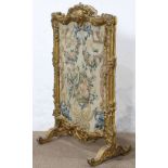 Louis XV style giltwood carved fire screen, having a molded frame, with a shell crest, ornamented