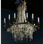 Continental crystal chandelier, having twelve lights suspended from the patinated support accented
