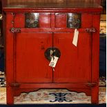 Chinese red lacquered wood cabinet, fronted by two drawers above hinged double doors, 33"h