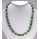 Jadeite and 14k yellow gold bead necklace Composed of (28) barrel shaped jadeite beads, measuring