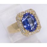 Tanzanite, diamond and 18k yellow gold ring Centering (1) oval-cut tanzanite, weighing approximately