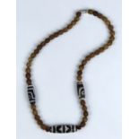 Sino-Tibetan necklace, composed of three dzi-type beads spaced by with seed beads with a textured
