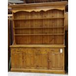 Large Primitive style pine cupboard, the superstructure having a molded top above the fixed shelves,