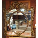 Renaissance style gilt looking glass, having a figural decorated crest with putti flanking the