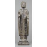 Asian stone sculpture of a standing Buddha, in abhaya and varada mudra, raised on a lotus