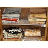 (lots of 14) Two shelves of Japanese textiles, mostly of obi woved with patterns such as cranes,