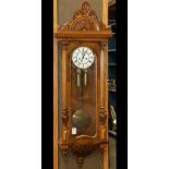 Austrian walnut regulator wall clock, having a carved crest, above the case having a single door