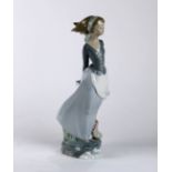 Llardo Daisa porcelain figure, depicting a woman with a book and basket of flowers, rising on