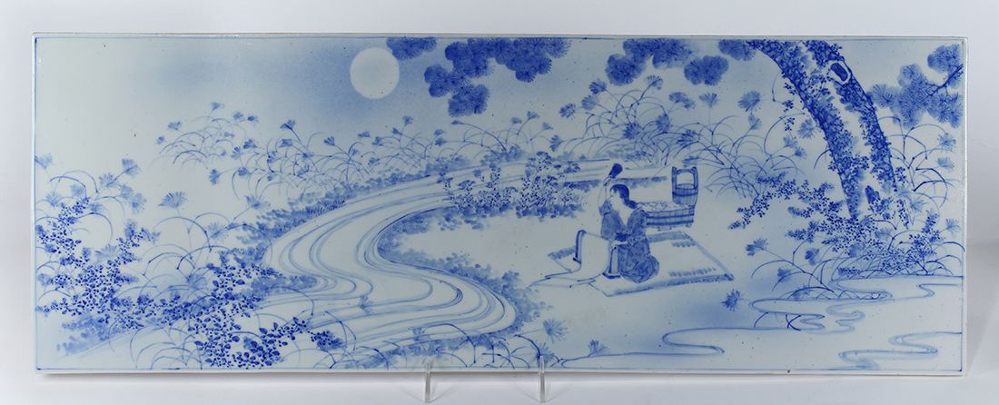 Japanese underglaze blue porcelain plaque, of a beauty washing clothing by the river, 30.5"w