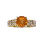 Garnet, diamond and 18k yellow gold ring Featuring (1) round-cut mandarin garnet, weighing