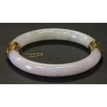 Jadeite and 14k yellow gold bangle bracelet Featuring (2) carved jadeite segments, measuring