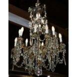 Continental crystal and gilt bronze chandelier, having twelve lights each rising on an S form