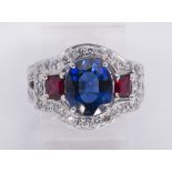 Sapphire, ruby, diamond and 14k white gold ring Centering (1) oval-cut sapphire, weighing