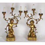 Pair of Rococo style giltwood candelabra, having three lights, with scrolled arms, and rising on a