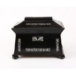 Victorian casket form tea caddy, ebonized with inlaid mother of pearl, and rising on compressed