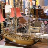 Wooden ship model, depicting a French Naval ship, with rigging and guns, and bearing flags with