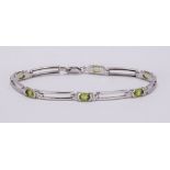 Peridot and 18k white gold bracelet Featuring (6) oval-cut peridots, weighing a total of