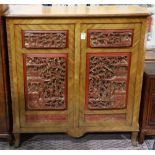 French style cabinet, the hinged doors each inset with two gilt and red lacquered panels carved with